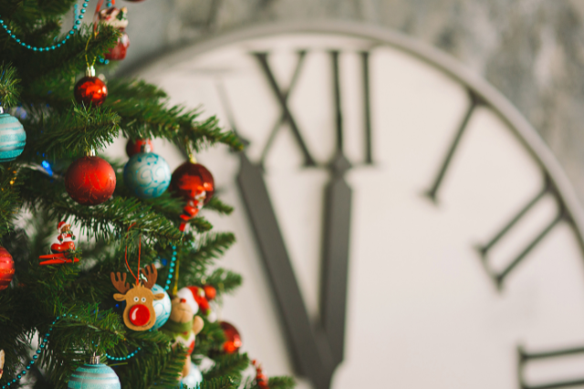 Symbolbild: Weihnachtsbaum mit einer großen Uhr im Hintergrund